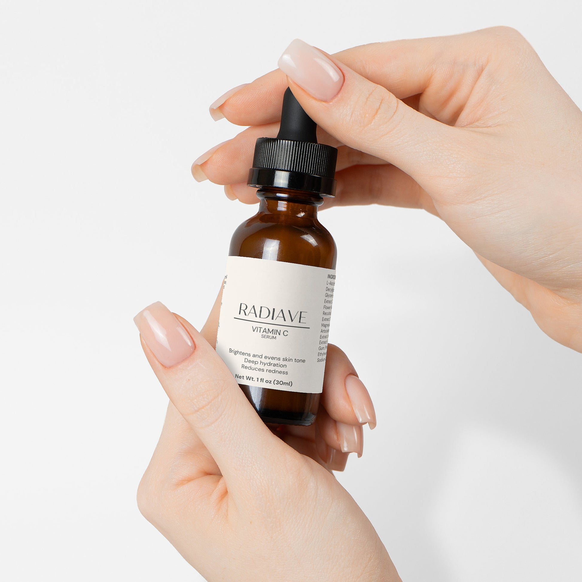 Hand holding a bottle of Radiave skincare serum against a white background