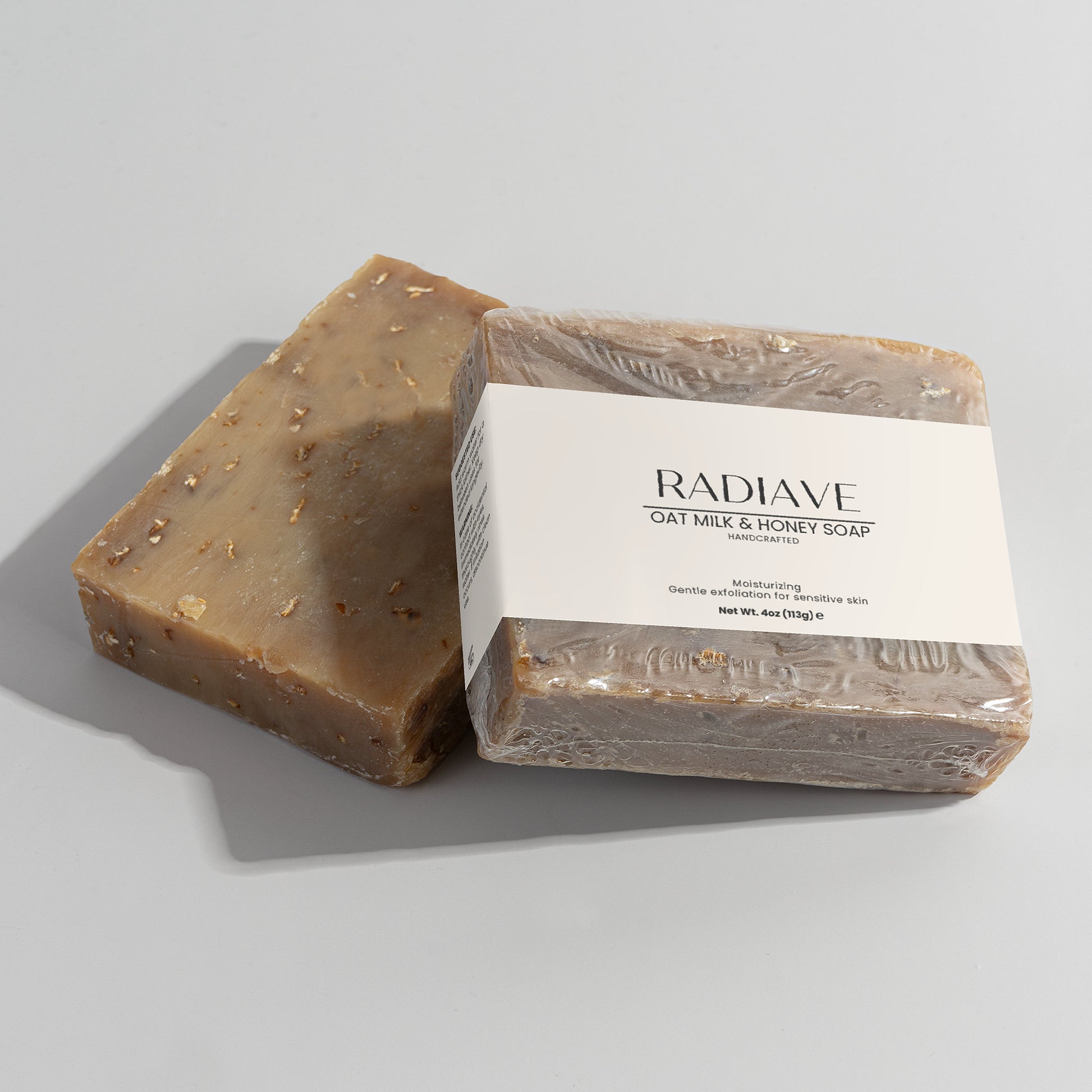 Two bars of Radiave oat milk and honey soap on a light gray background